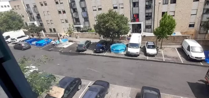 Moradores montam piscinas em parque de estacionamento para usar durante vaga de calor, em Oeiras