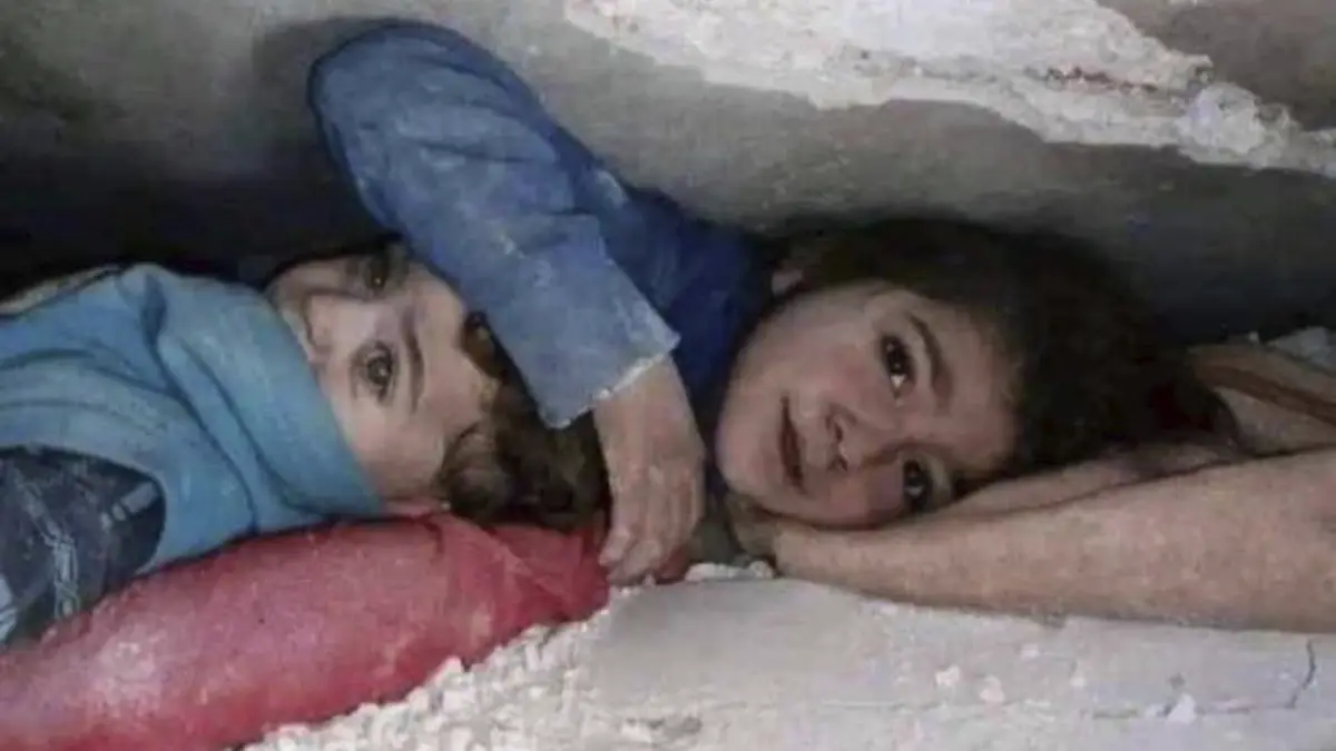 Menina protege irmão mais novo enquanto esperam para ser salvos dos escombros dos sismos na Turquia